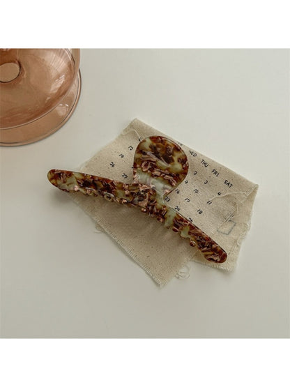 Beau chic acetate claw clip in a hand to show size and scale