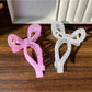 Beau sheer bow shape claw clip held in hand displaying size and translucency