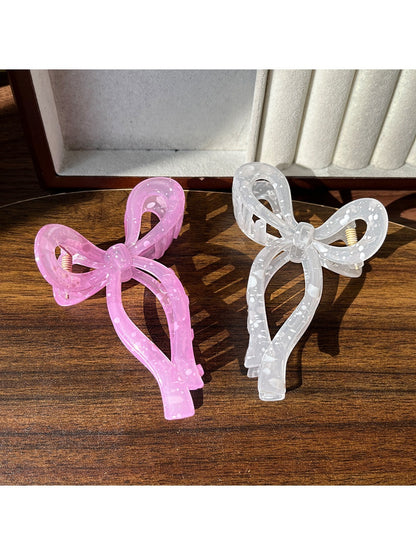 Beau sheer bow shape claw clip held in hand displaying size and translucency