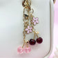 Cherry charm keychain attached to a set of keys on a wooden surface