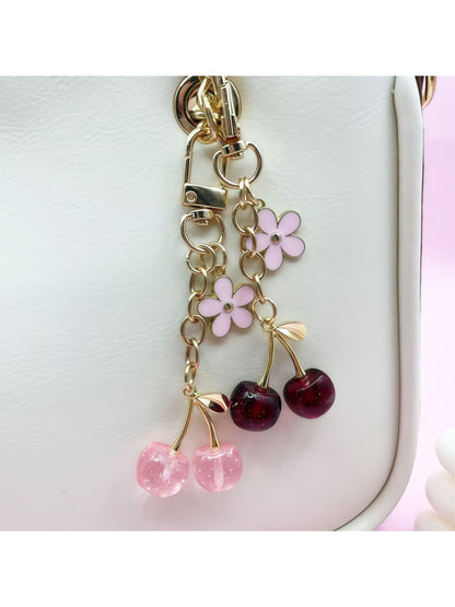 Cherry charm keychain attached to a set of keys on a wooden surface