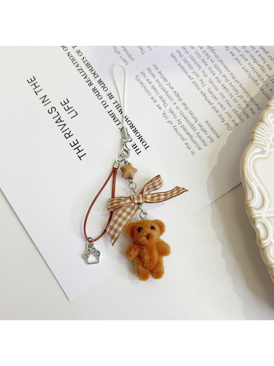 Keypus bear bag charm hanging from a backpack zipper pull