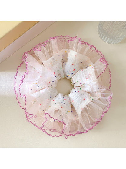 Polka dot ruffle scrunchie styled on a wrist as an accessory