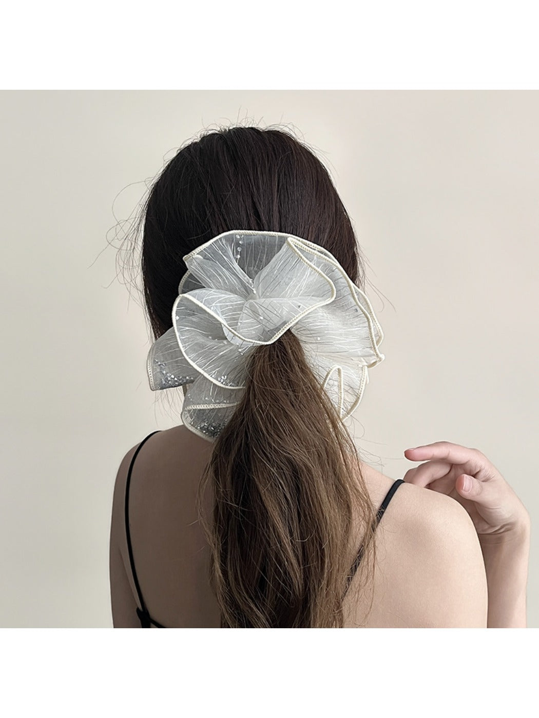 Gifty scrunchie styled on a wrist, highlighting its double layer ruched design