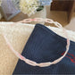 Gifty acetate chain style headband placed on wooden surface with natural lighting