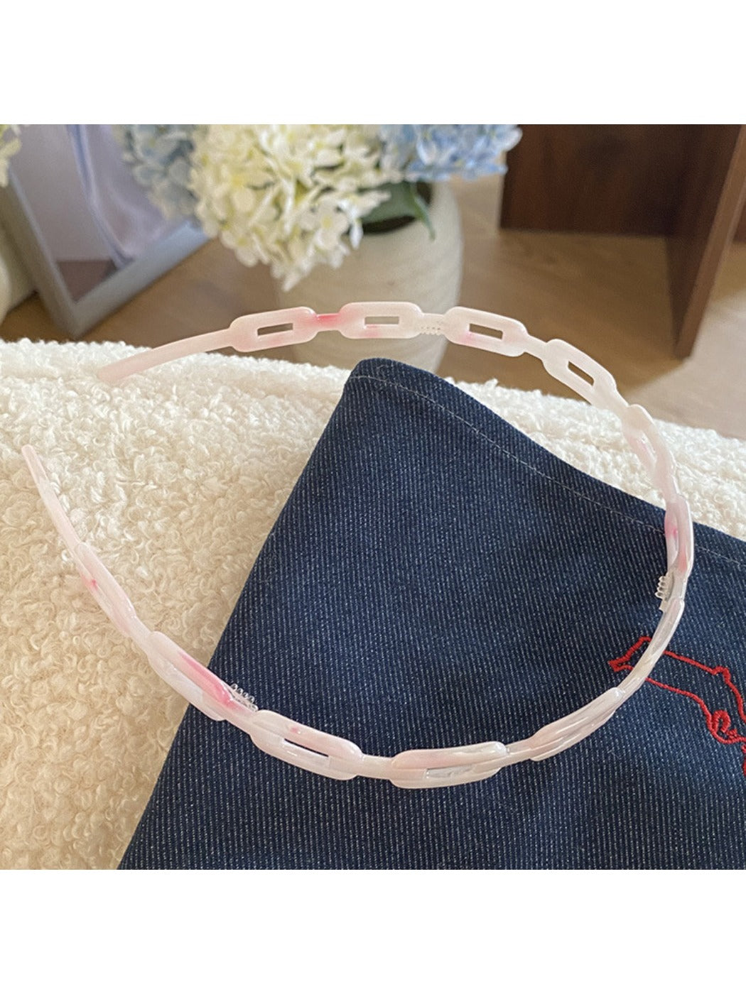 Gifty acetate chain style headband placed on wooden surface with natural lighting