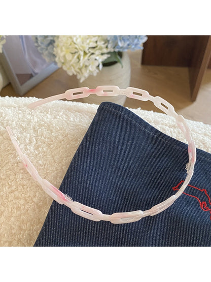 Gifty acetate chain style headband placed on wooden surface with natural lighting