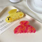 Beau hair claw clip held in hand displaying size and curved half round shape