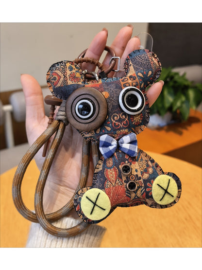 Bear keychain hanging from a set of keys on a wooden surface