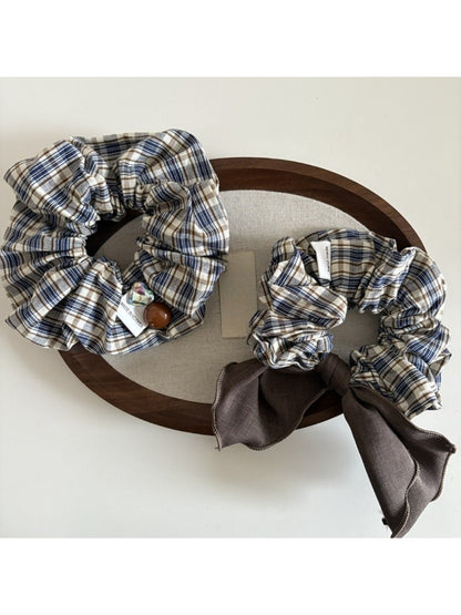Close-up of Gifty vintage plaid bow scrunchie in red and beige tones