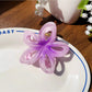 Beau flower hair claw clip clipped into thick hair from the back
