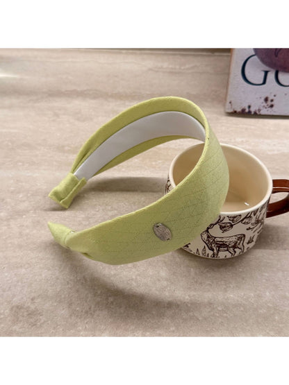 Gifty wide headband in solid color styled with hair pulled back