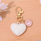 Heart shaped bag charm keychain held in hand to show size and scale