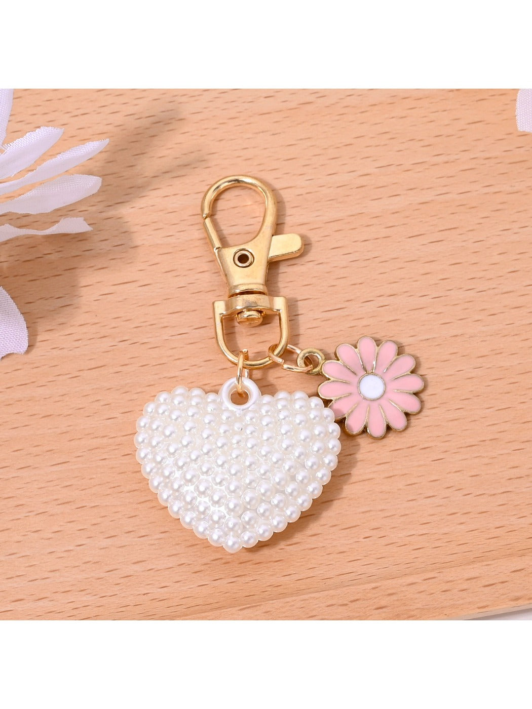 Heart shaped bag charm keychain held in hand to show size and scale