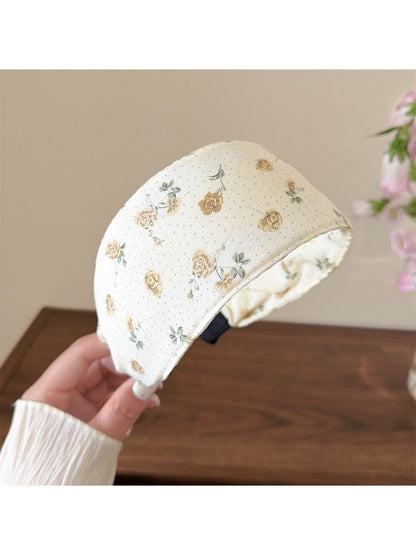 Close-up of cute fabric headband featuring pastel flowers and soft texture