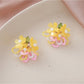 Earedge small flower cluster earrings with multicolor beads shown against dark background