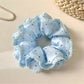 Pink polka dot scrunchie holding a ponytail hairstyle