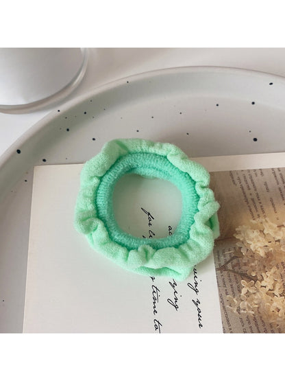 Flat lay of assorted colorful ruffled hair ties with a gift box