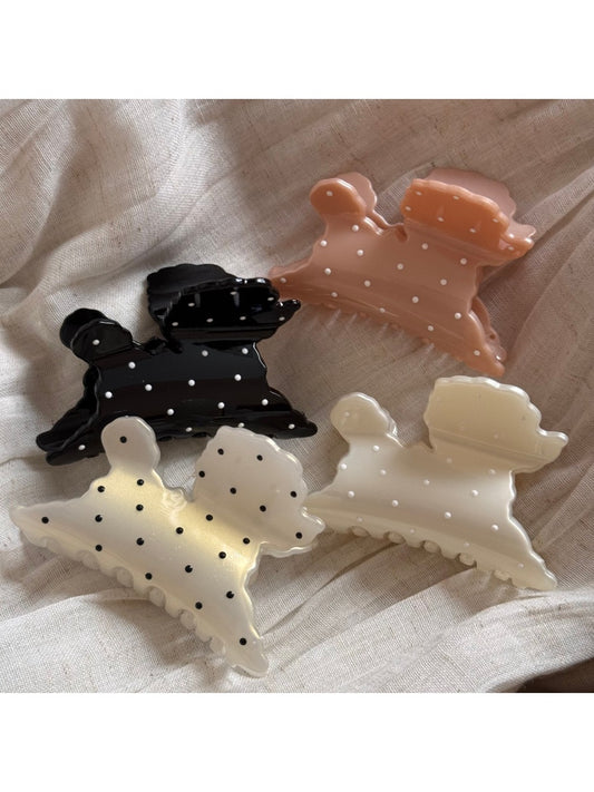 Beau polka dot puppy shaped hair clip with black and white spots on a white background