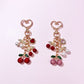 Close-up of Keypus cherry charm keychain with red enamel cherries and green leaves