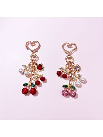 Close-up of Keypus cherry charm keychain with red enamel cherries and green leaves