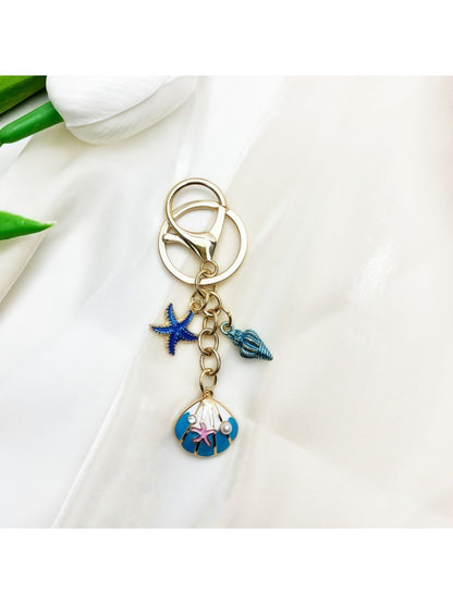 Keypus marine inspired keychain placed next to a seashell for thematic effect
