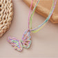 Raffia butterfly pendant necklace worn on a model's neck