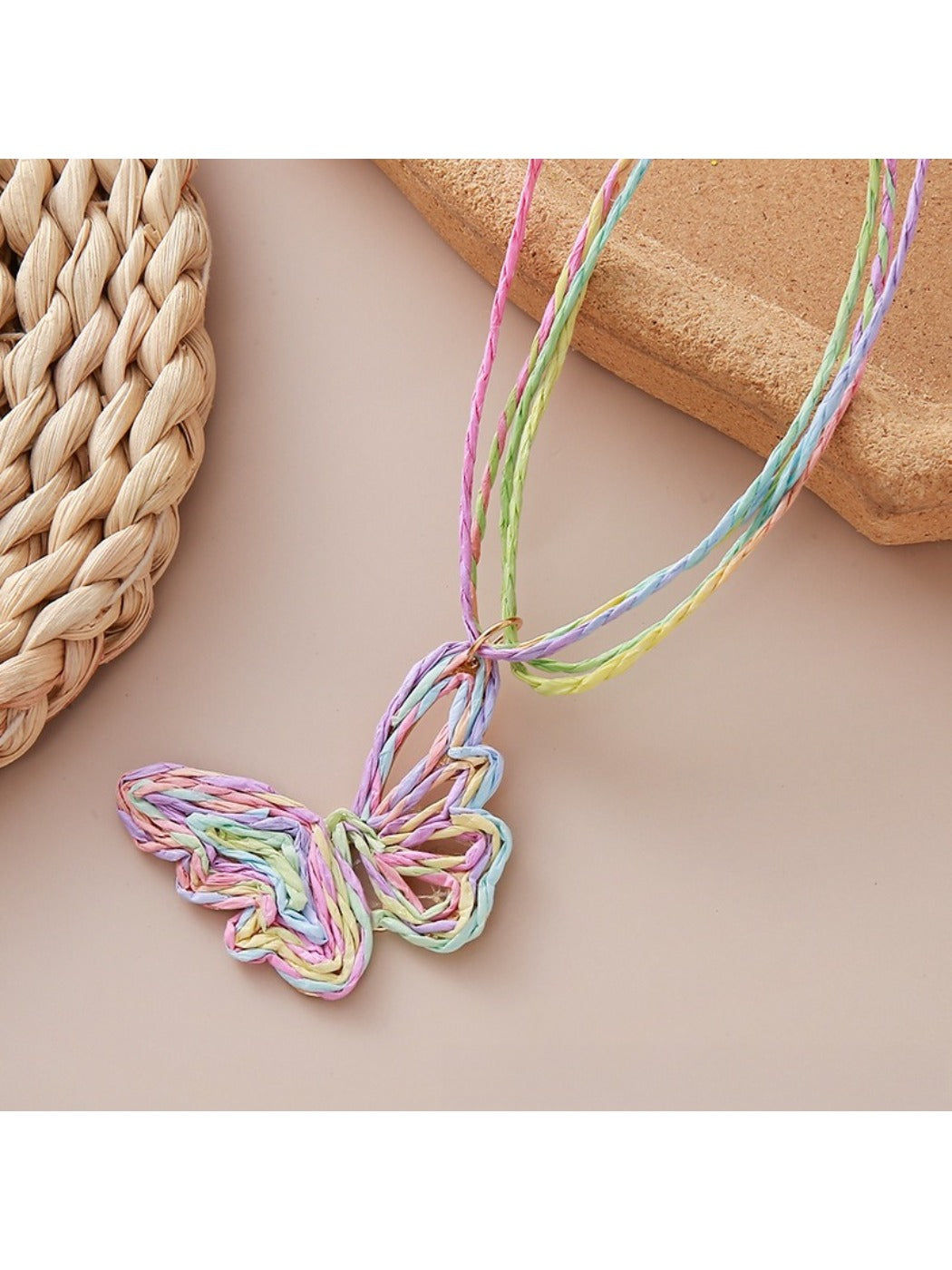 Raffia butterfly pendant necklace worn on a model's neck