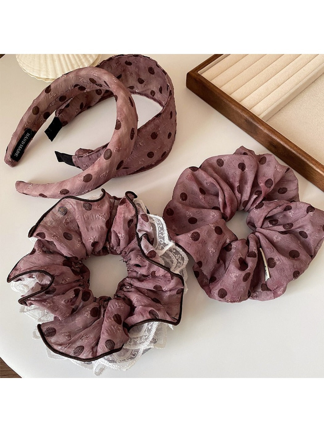 Black and white polka dot ruffled headband displayed flat