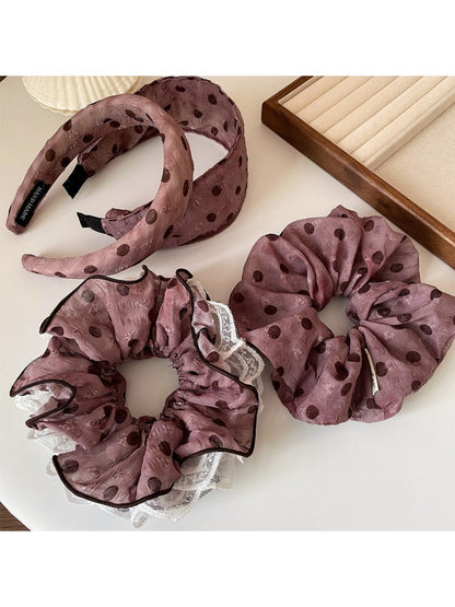 Black and white polka dot ruffled headband displayed flat