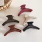 Close-up of Beau polka dot acetate hair clip showing glossy finish and curved shape