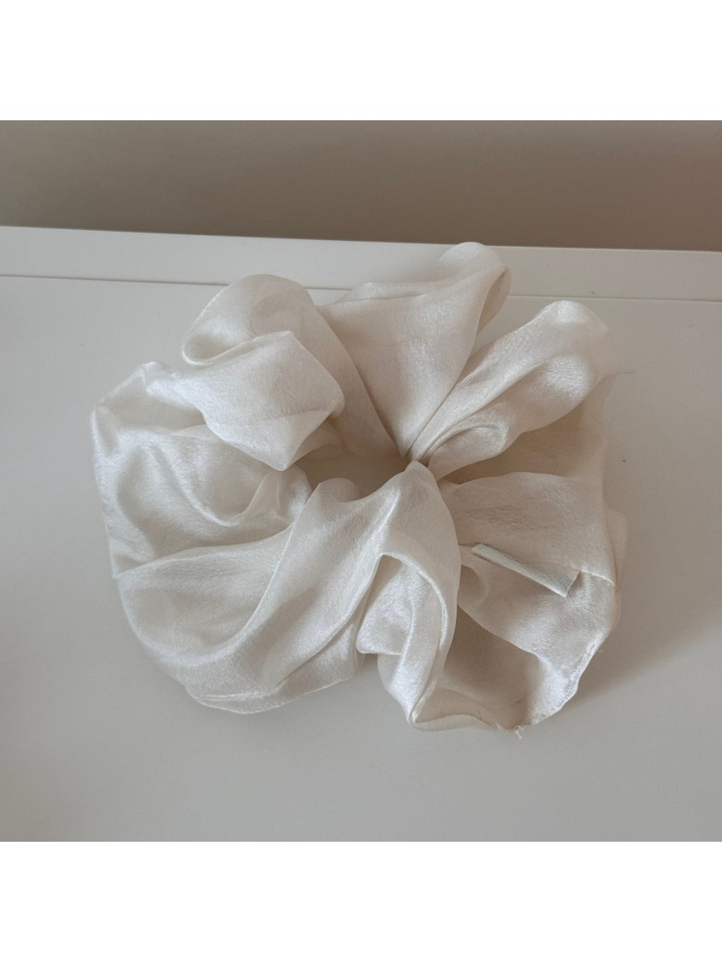 Scrunchie styled on a wrist as a fashion accessory with soft pastel tones