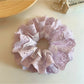 Purple double scrunchie styled on a wrist with cutout pattern