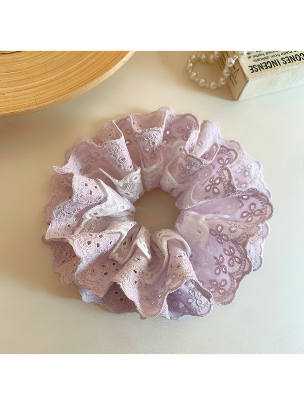 Purple double scrunchie styled on a wrist with cutout pattern