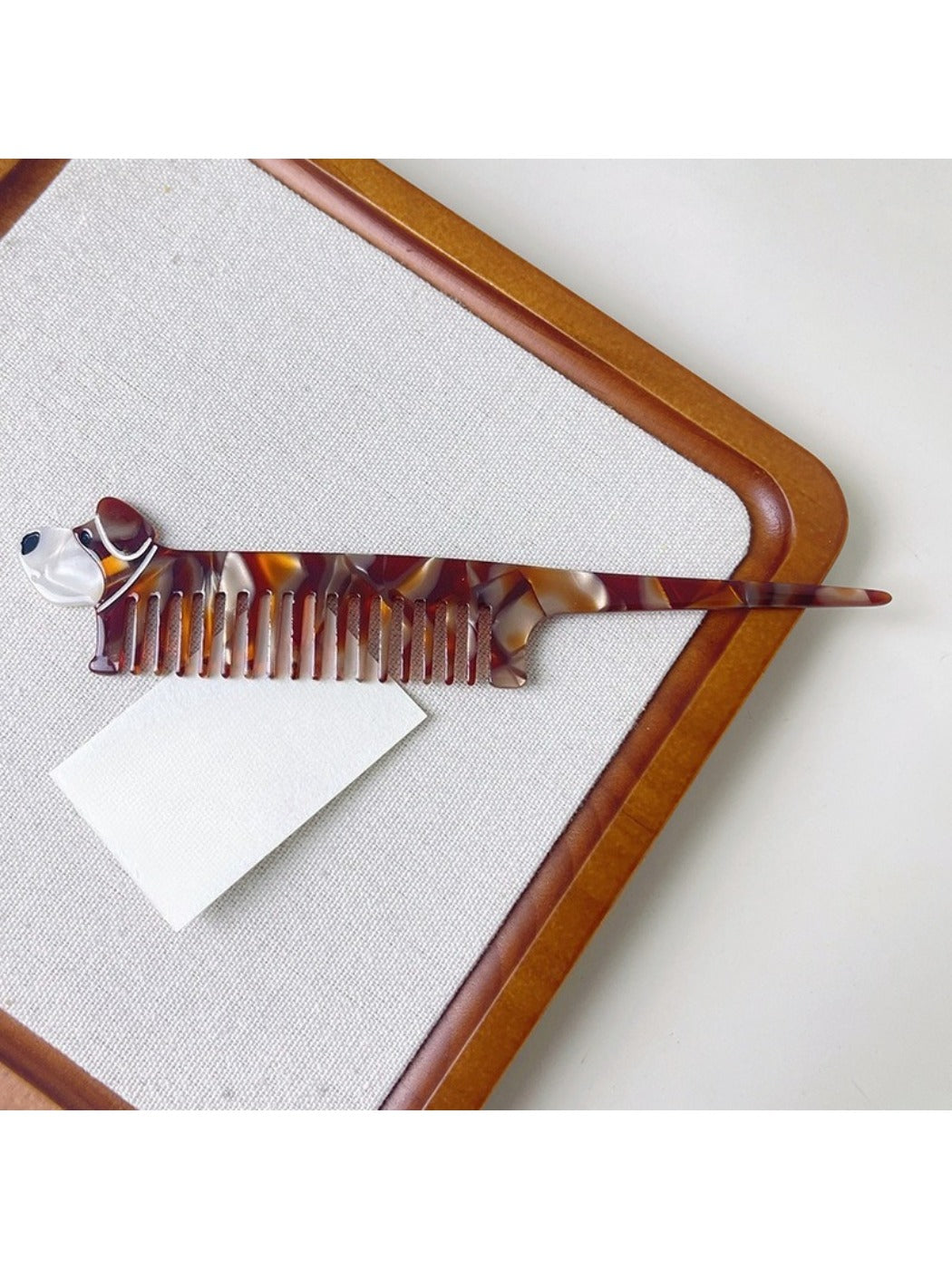 Hand holding Camerow creative hair comb with tortoiseshell design