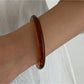 Lovra wide round bangle bracelet photographed with soft shadows emphasizing its round shape