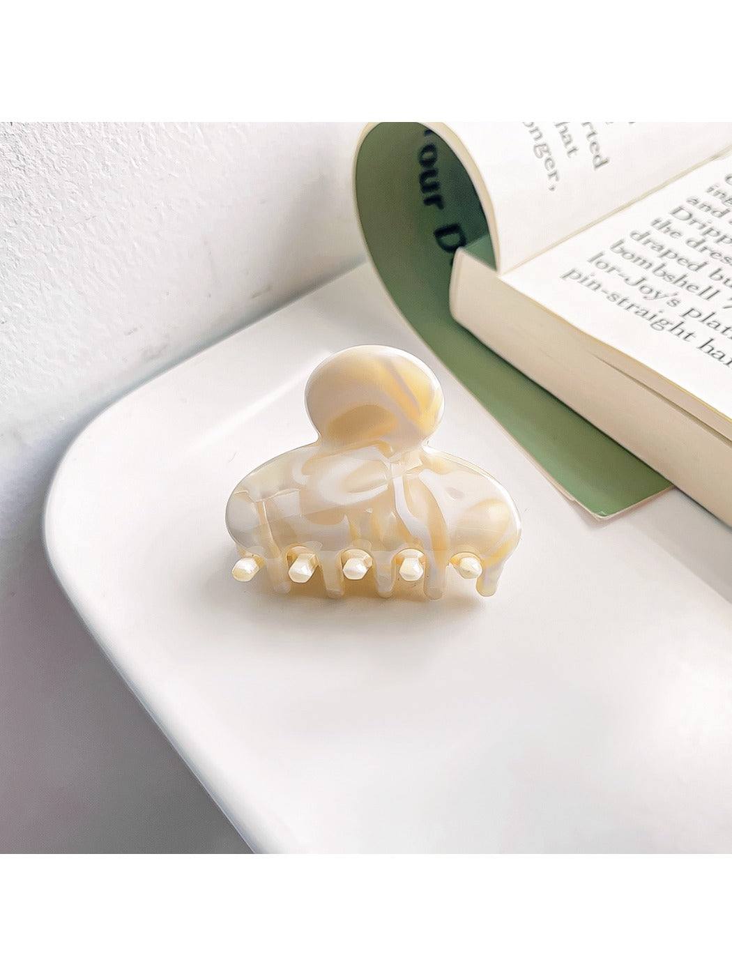 Beau vintage small crescent shaped claw clip in natural light showing color variations
