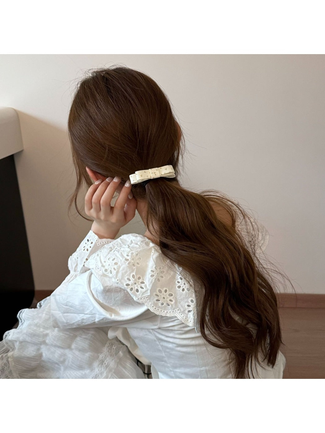 Gifty bow embellished hair tie wrapped around a ponytail on a model