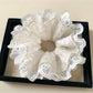 Model wearing Gifty cutout ruffled scrunchie in hair, styled in a ponytail