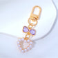 Hand holding a cute beaded heart keychain with pink and white beads