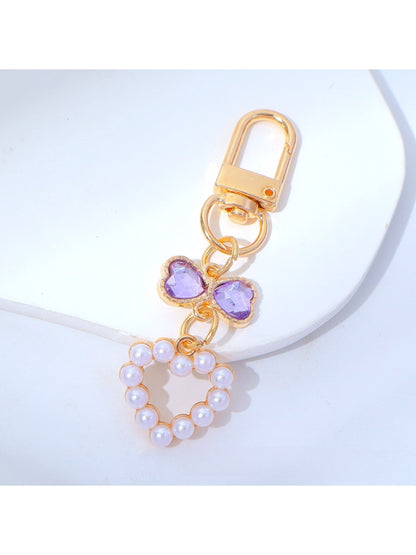 Hand holding a cute beaded heart keychain with pink and white beads
