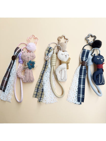 Fabric cat shaped keychain with embroidered details and a metal keyring