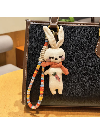 Hand holding the vintage rabbit charm keychain showing its size and detail