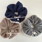White lace scrunchie with bow tied around a ponytail on a model with blonde hair