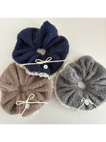 White lace scrunchie with bow tied around a ponytail on a model with blonde hair