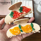 Orange fruit shaped claw clip attached to brown hair