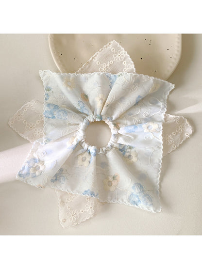 Multiple Gifty scrunchies displayed in a flat lay with vibrant patterns and textures
