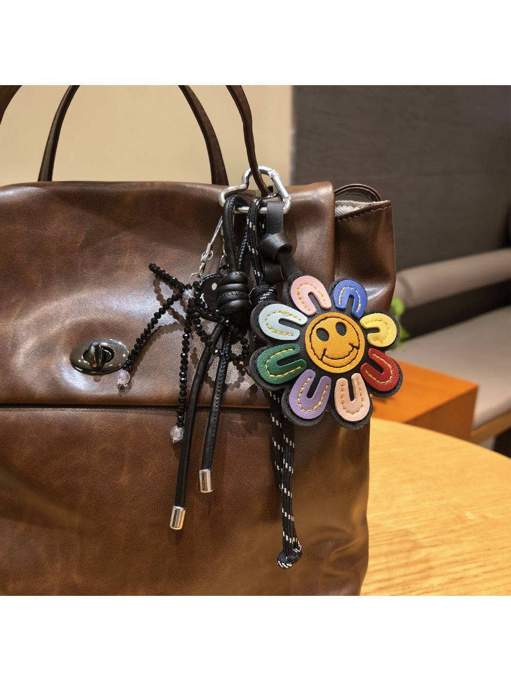 Rainbow sunflower keychain held in hand showing size and colorful design