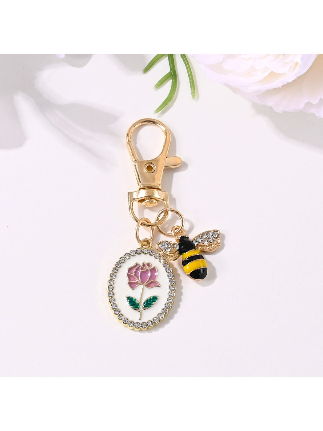 Side view of the rose flower print keychain highlighting the metal texture