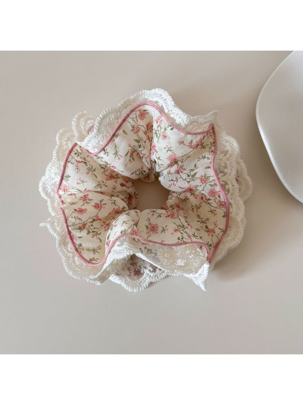 Gifty scrunchie showing pink and green floral pattern with delicate white lace edging